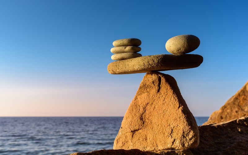 rocks balancing on larger rocks against a blue sky