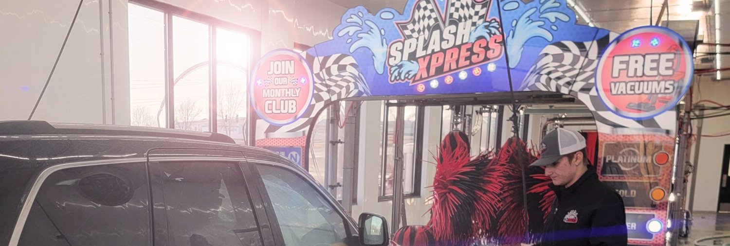 car wash attendant standing in front of a Splash Xpress sign